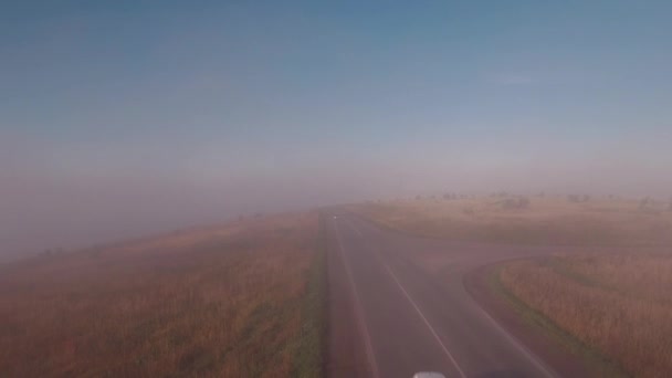 Vliegen over mistige weg in de herfst platteland. 4k — Stockvideo