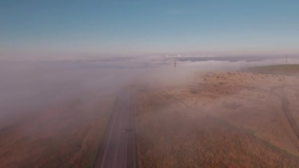 Vliegen over mistige weg in de herfst platteland. 4k — Stockvideo