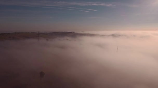 Luchtfoto van herfst mistige landschap bij zonsopgang. Mist heeft betrekking op de heuvels in de ochtend zon. 4k — Stockvideo