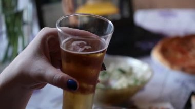 Bir bardak su ile soğuk ışık bira tutan kadının el bırakır. ağır çekim