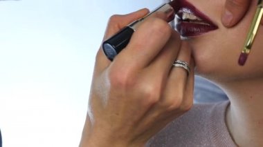 Profesyonel makyaj: baştan çıkarıcı genç model dudaklarında kırmızı ruj. ağır çekim