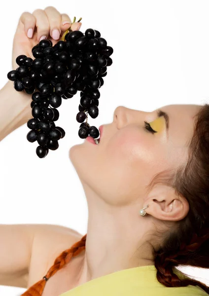 Hermosa pelirroja está comiendo uvas negras. concepto de alimentación saludable — Foto de Stock