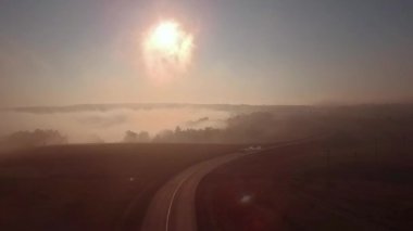 Otoban yol sisli gündoğumu ve araba silüeti