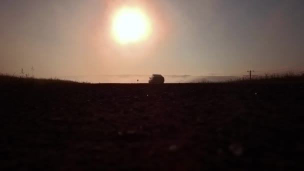 Estrada rodoviária no nascer do sol nebuloso e silhueta de carro — Vídeo de Stock