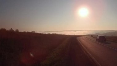 Otoban yol sisli gündoğumu ve araba silüeti