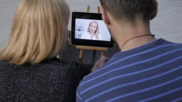 Ζευγάρι έχοντας συνομιλία μέσω βίντεο με οικογενειακό γιατρό. ηλεκτρονικές διαβουλεύσεις — Αρχείο Βίντεο