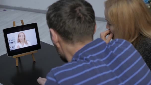 Ζευγάρι έχοντας συνομιλία μέσω βίντεο με οικογενειακό γιατρό. ηλεκτρονικές διαβουλεύσεις — Αρχείο Βίντεο