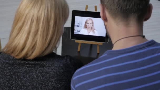 Der Arzt berichtet per Videochat mit einem Ehepaar über die Ergebnisse der medizinischen Untersuchung. Online-Medizin — Stockvideo