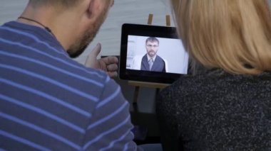 Doktor evli bir çift ile görüntülü sohbet tarafından muayene sonuçlarını bildirir. on-line tıp