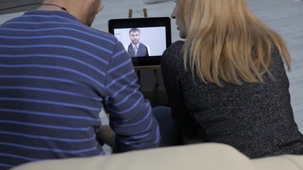 Médico relata os resultados do exame médico por vídeo chat com um casal. medicamento em linha — Vídeo de Stock