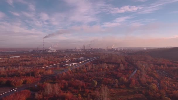 Top uitzicht, antenne: herfst landschap en fabrieksinstallaties. Luchtverontreiniging door emissies van industriële installaties. Pijpen rook in de lucht gooien. 4k — Stockvideo