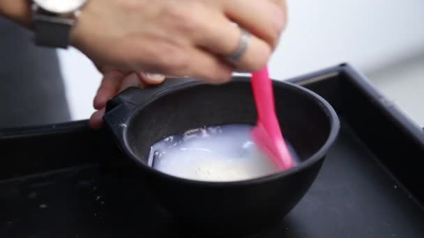 Hair dye preparation, colorist stirs with a brush, beauty salon concept — Stock Video