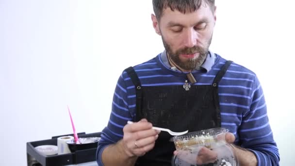 Männliche Stylistin essen am Arbeitsplatz zu Mittag, gutaussehender Typ mit Lunchbox — Stockvideo