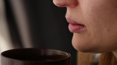 güzel kadın içecek kahve veya çay pencereden dışarı bakarak. ağır çekim