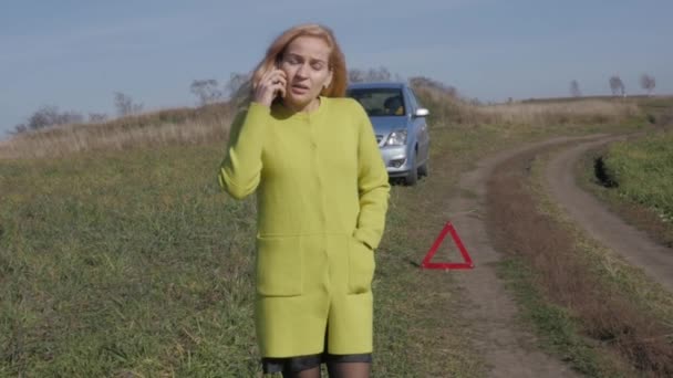 Triste encantadora mujer de negocios cerca de coche roto en la carretera rural está llamando por teléfono móvil. cámara lenta — Vídeo de stock