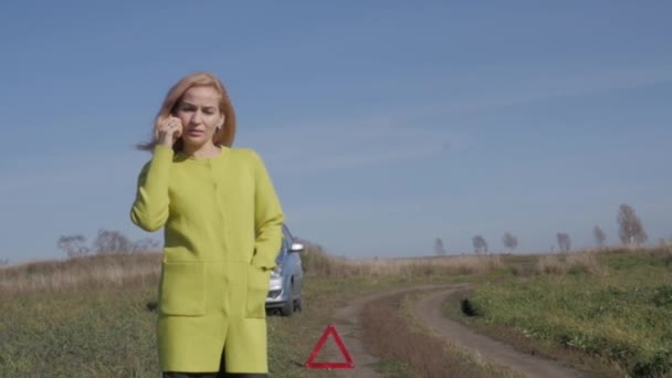 Üzgün büyüleyici iş kadını yakınındaki kırsal yolda kırık araba üstünde hareket eden telefon arıyor. ağır çekim — Stok video