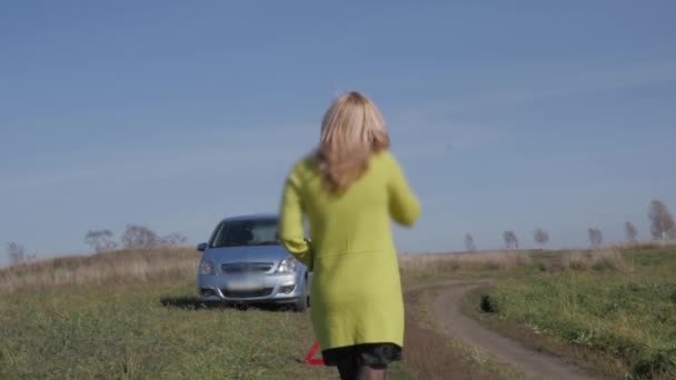 Чарівна бізнес-леді кличе на допомогу по мобільному телефону. дівчина біля розбитої машини на сільській дорозі. повільний рух — стокове відео
