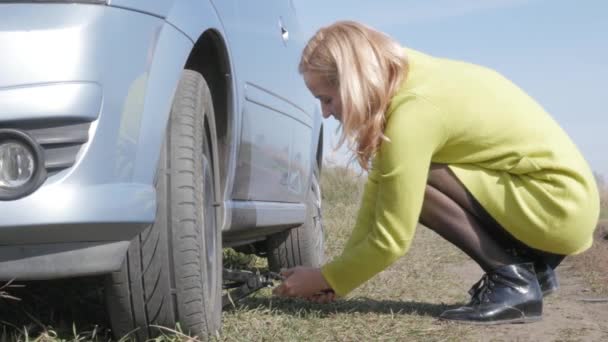 Triste encantadora joven levantando coche roto con tornillo de gato en la carretera rural. 4K — Vídeos de Stock