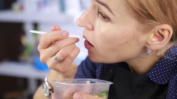 Blonde Mädchen essen am Arbeitsplatz zu Mittag, Fast-Junk-Food. Friseur mit Lunchbox — Stockvideo
