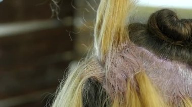 Kuaför Güzellik Salonu bir genç için boya saç modeli, yapar. Saç boya kaplı. ağır çekim