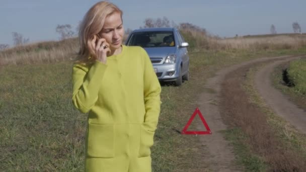Charmiga affärskvinna efterlyser hjälp av mobiltelefon. flicka nära trasiga bil på lantlig väg. 4k — Stockvideo