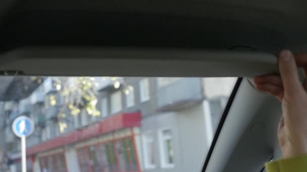 Young glamorous woman is fixing her makeup in a car looking to rearview mirror. slow motion — Stock Video