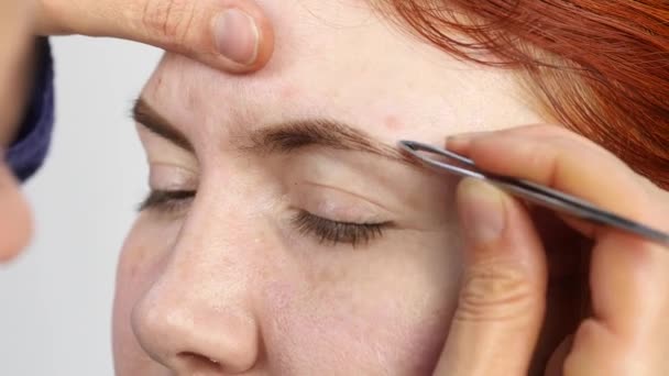 Maquillaje profesional artista dibujando cejas de hermoso cliente. Concepto de belleza y moda — Vídeo de stock