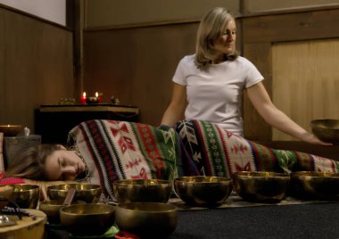 Tibet singing kaseler ile çalışan kadın. yoga eğitmeni meditasyon yapar. ağır çekim
