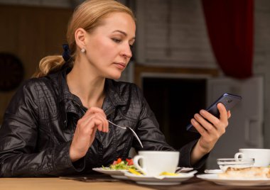 açık bir kafede öğle yemeği. salata ve kontrol e-posta üstünde senin telefon yeme işkadını