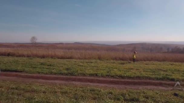Vue aérienne. femme blonde sur une route rurale d'automne près de voiture cassée. 4K 