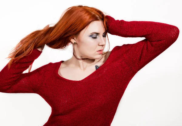 Красивая сексуальная рыжая женщина в красном свитере на белом фоне — стоковое фото