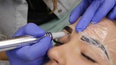 Genç güzel kadın Başlarken kaşları dövme. kalıcı makyaj Güzellik Salonu kaşları için. ağır çekim