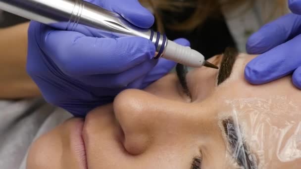 Primer plano manos del maestro haciendo cejas tatuaje. maquillaje permanente de la ceja — Vídeos de Stock