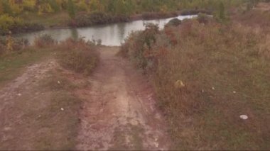 Havadan görünümü: uçuş ile küçük bir göl köy yolunda, Ufukta fırtına bulutları