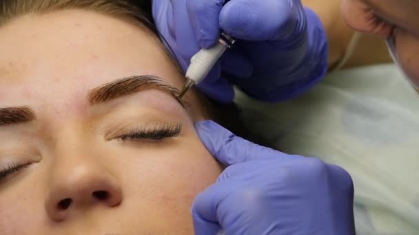 Mãos close-up do mestre fazendo tatuagem sobrancelhas. Maquiagem permanente da sobrancelha. câmara lenta — Vídeo de Stock