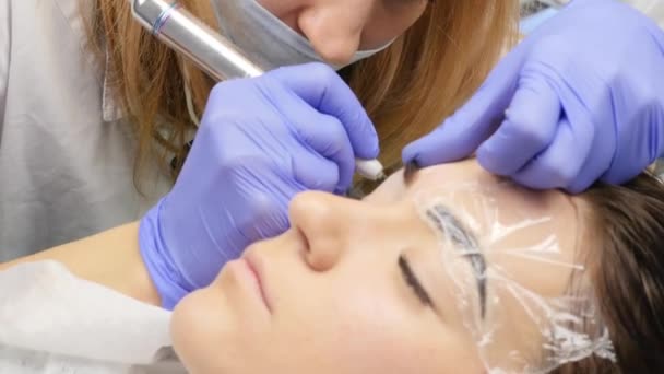 Kosmetolog gör bryn tatuering till kvinnlig kund. professionella ögonbryn permanent makeup. 4k — Stockvideo