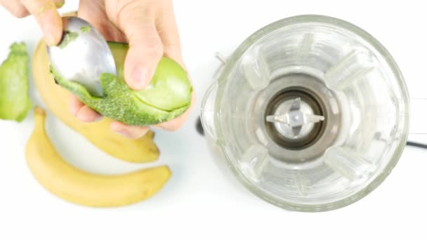 Frau schält eine Avocado für Smoothies Coctel Zubereitung. 4k — Stockvideo