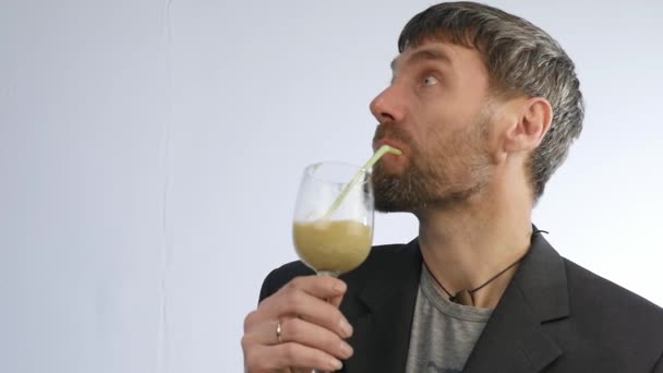 Bebaarde man drinkt cocktail uit groente- en fruitsector. Detox smoothie, gezonde levensstijl concept. Slow motion — Stockvideo