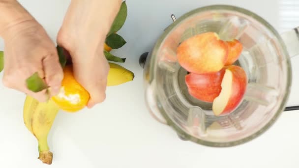 Προετοιμασία ενός κοκτέιλ φρούτων σε ένα μπλέντερ, smoothies. Το Top view. Γυμναστήριο και έννοια του υγιεινού τρόπου ζωής. 4k — Αρχείο Βίντεο