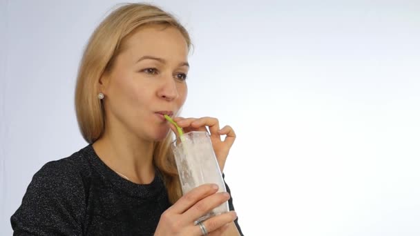 Blonde vrouw drinkt fruit cocktail, detox smoothie. Fitness en gezonde levensstijl concept. Slow motion — Stockvideo