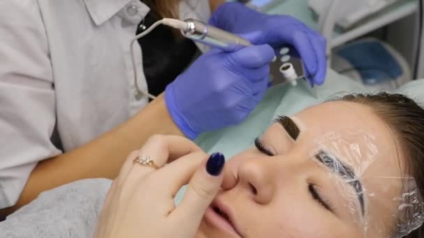 Ung vacker kvinna att få ögonbrynen tatuering. permanent makeup för ögonbrynen på skönhetssalong. slowmotion — Stockvideo