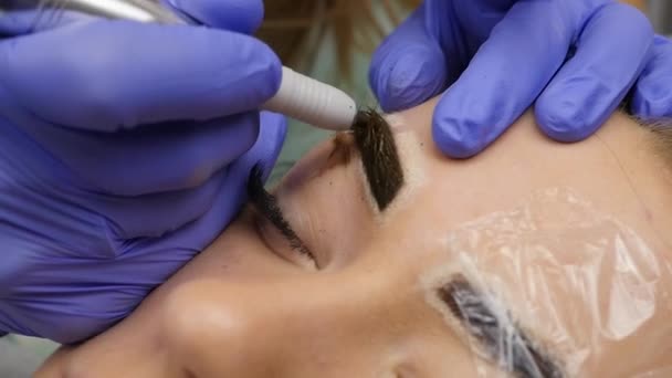 Maquiagem permanente de sobrancelha profissional. Tatuagem de sobrancelhas close-up. câmara lenta — Vídeo de Stock
