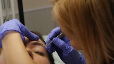 Genç güzel kadın Başlarken kaşları dövme. kalıcı makyaj Güzellik Salonu kaşları için. ağır çekim