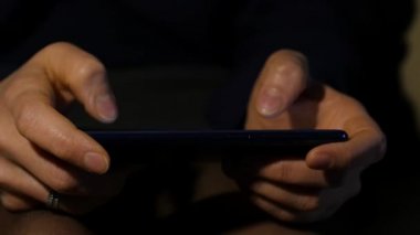 Bayan parmak yakından gece smartphone kullanarak. bir cep telefonu internet tarama kız. ağır çekim