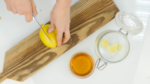 Birisi bir limon Doğrama tahtası üzerinde kesme. üstten görünüm — Stok video