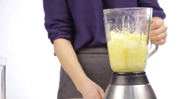 Femme préparant un cocktail de fruits dans un mélangeur, préparation de smoothies . — Video