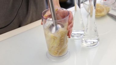 Kadın bir meyve kokteyli smoothies bir karıştırıcıda hazırlık kavun tohumu süt ile yapım..
