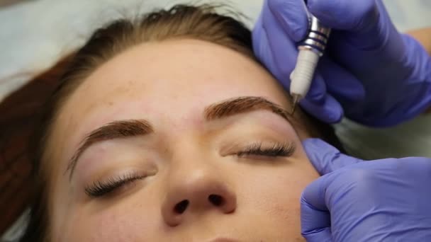 Jeune belle femme se faisant tatouer les sourcils. maquillage permanent pour les sourcils au salon de beauté. au ralenti — Video