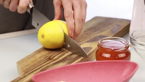 Mujer cortando un limón en la tabla de cortar — Vídeo de stock