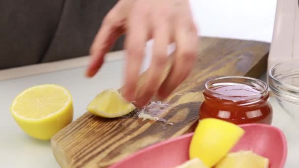 Mujer cortando un limón en la tabla de cortar — Vídeos de Stock